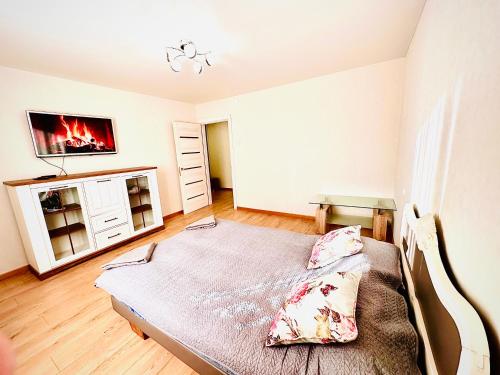 a bedroom with a bed and a tv on a wall at M&M Apartment VI SELF CHECK-IN in Panevėžys