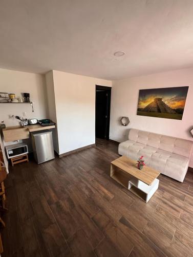 a living room with a white couch and a table at Departamentos Naa'y in Valladolid