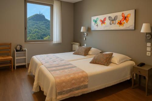 Un dormitorio con una cama grande con ventana. en Logis Hôtel Restaurant de la Paix, en Lodève