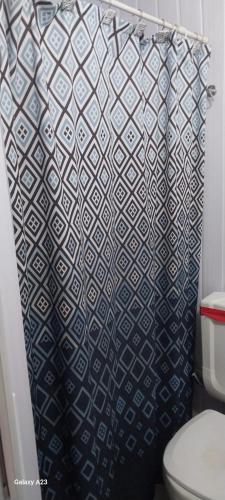 a bathroom with a black and white shower curtain at Recanto do pepe in Xuí