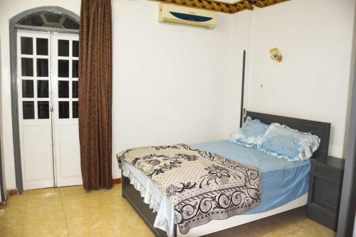 a bedroom with a bed with blue pillows on it at Pauline Guest House in Luxor