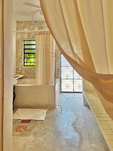 a bathroom with a tub and a shower curtain at Casa Arcana Boutique in Mérida