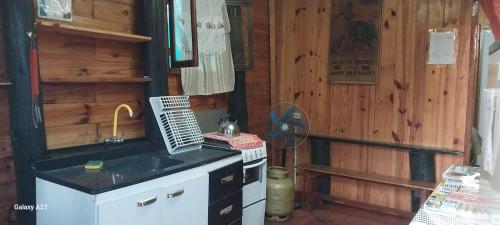a kitchen with a sink and a stove in a cabin at Recanto do pepe in Chuí
