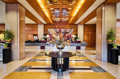 a lobby with a vase of flowers on a table at Mandarin Oriental, Boston in Boston