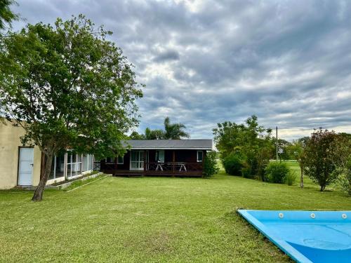a house with a yard with a blue trampoline at Cabaña Lomas Del Delta in Esquina