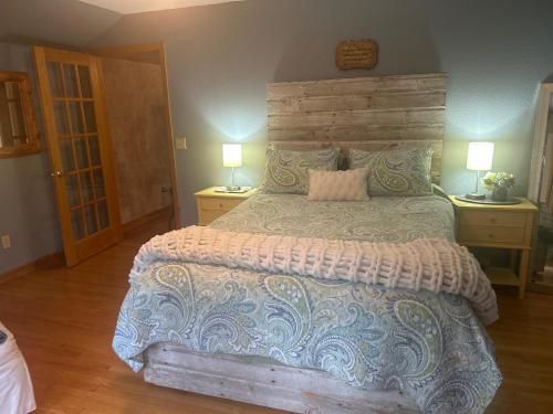 Un dormitorio con una cama grande y dos lámparas. en Bed and breakfast suite at the Wooded Retreat, en Pine City