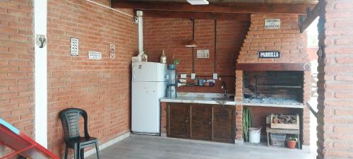 een keuken met een witte koelkast in een bakstenen muur bij Quincho Gala in El Cadillal