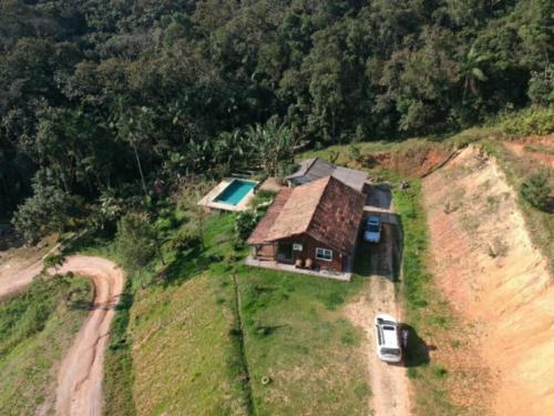 a small house on top of a hill with a car at Pool amid the green in Gaspar