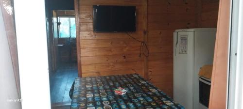 a room with a refrigerator and a television and a bed at Cabañas Recanto do pepe in Santa Vitória do Palmar