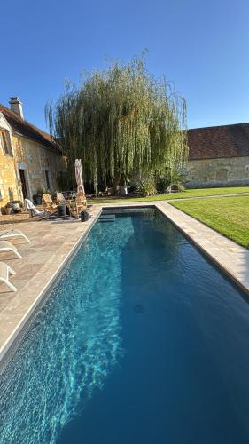 a swimming pool with blue water in a yard at Le Relai Valdieu in Courgeon