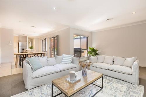 a living room with two white couches and a table at Mildura City Centre Escape 2 in Mildura