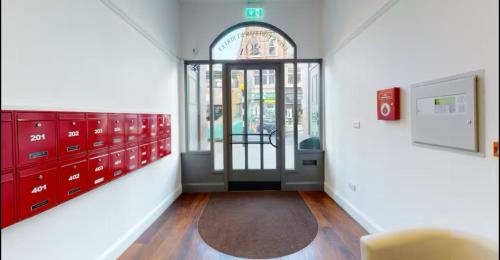 a hallway with red lockers and a door in a room at Modern Studio, Top Floor, King Street Views in Nottingham
