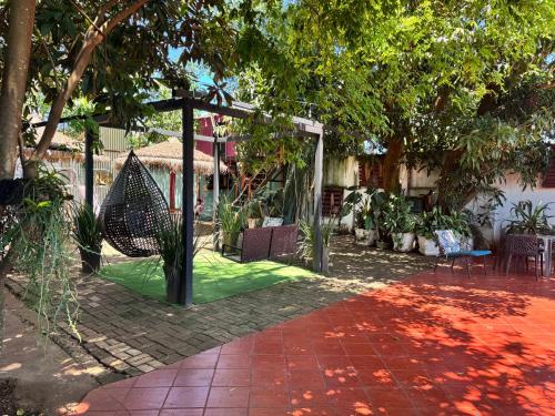 a patio with a hammock and trees in a yard at Los Monges Aparthotel in Ciudad del Este