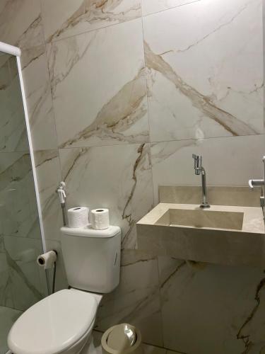 a bathroom with a white toilet and a sink at Suite Tarituba 3 in Angra dos Reis