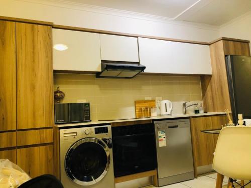 a kitchen with a washing machine in a kitchen at Apartment at the Blyde in Pretoria