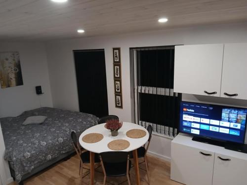 a bedroom with a table and a bed and a television at Cozy Cottage Near the Skjern River in Tarm
