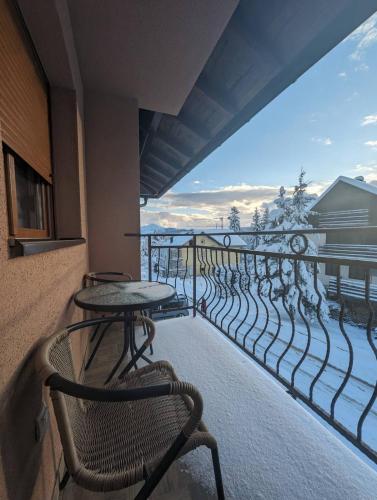 兹拉蒂博尔Zlatiborske noći的配有桌椅并可欣赏海景的阳台