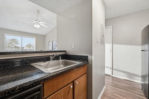 una cocina con fregadero y refrigerador en District West Apartments Simple Modern Home, en Doud