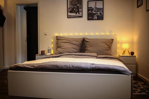 a bedroom with a large bed with lights on it at Lumé26 in Koblenz