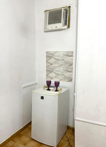 a room with a heater and two purple glasses on a cabinet at Quarto privado no centro 313 in Manaus