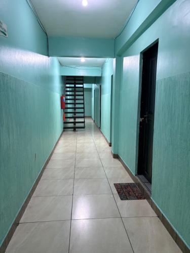 un pasillo vacío con paredes verdes y una escalera en Quarto privado no centro 313, en Manaus
