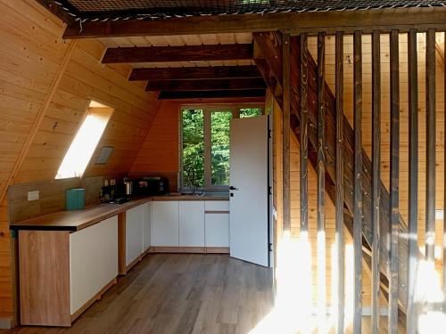 a kitchen with white cabinets and a staircase in a cabin at М'юзіка Карпат in Yavoriv