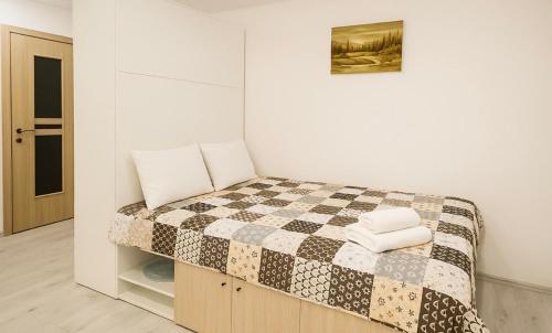 een slaapkamer met een bed met een geruite deken bij M&M Apartment I SELF CHECK-IN near Panevezys in Velžys