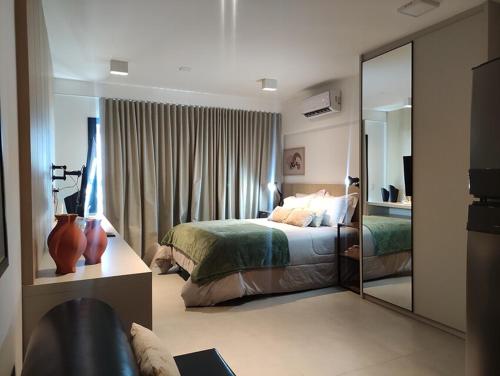 a bedroom with a bed and a large mirror at Estúdio completo e charmoso in Marília