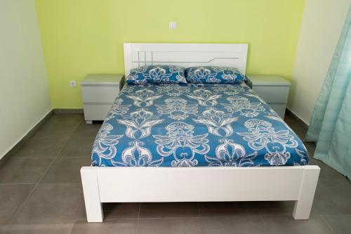 a bed with a blue and white comforter and pillows at Quarto com Vista para o Vale in Ribeira Grande