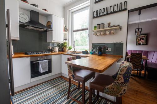 a kitchen with a table and some chairs in it at Traditional apt close to city centre & Hampden in Glasgow