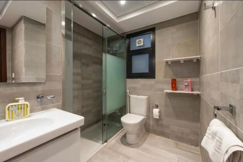 a bathroom with a toilet and a sink and a shower at Luxury Apartments in Cairo Festival City in Cairo
