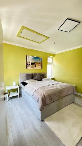 a bedroom with a bed and a yellow wall at Ferienhaus Am Trollmönch in Goslar