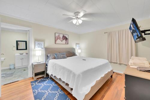 a bedroom with a bed and a ceiling fan at Park your Boat! Mins from the Ocean•Screened Porch in Harkers Island
