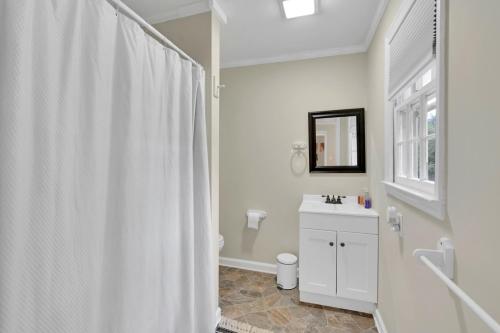 a bathroom with a white shower curtain and a sink at Park your Boat! Mins from the Ocean•Screened Porch in Harkers Island