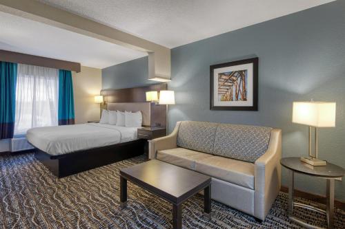 a hotel room with a bed and a couch at Best Western Waldo Inn & Suites in Waldo