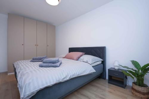 een slaapkamer met een bed met handdoeken erop bij Modern Apartment near Lake & Free parking & Easy City Access in Bratislava