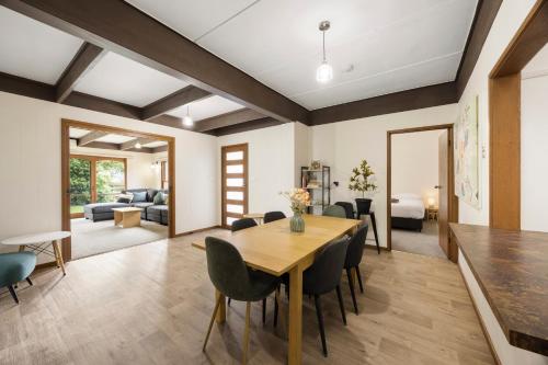 a dining room and living room with a wooden table and chairs at Maffra Motor Inn in Maffra
