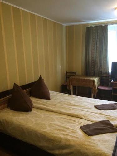 um quarto com uma cama grande num quarto em Strādnieku viesnīca em Ventspils