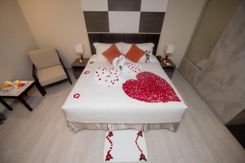 a bedroom with a white bed with hearts on it at Hotel Parami in Yangon
