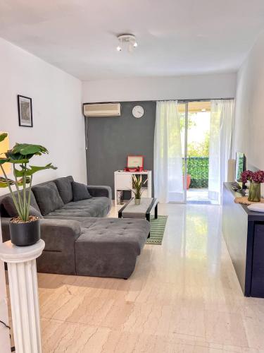 a living room with a couch and a table at Varkiza Beach Entire Apartment in Vari