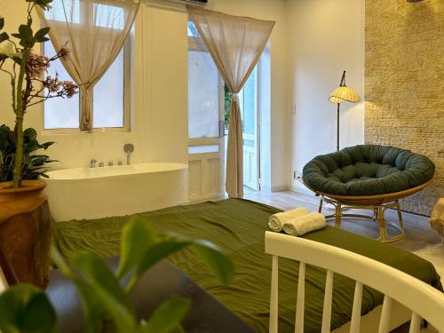 a large bathroom with a tub and a couch and a table at De'Lea Homestay & Hotel in Ho Chi Minh City