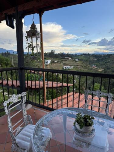 a table and chairs on a balcony with a view at Encantadora finca en el corazón de Marinilla con vistas únicas y ubicación privilegiada in Marinilla
