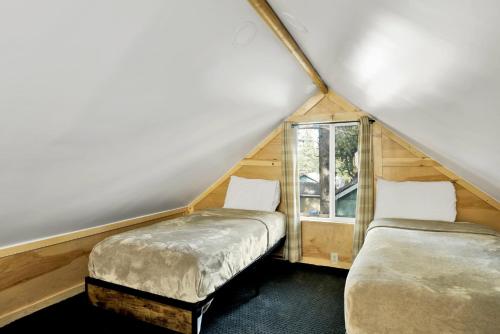 two beds in a small room with a window at Sugar Bear Chalet #2559 in Sugarloaf