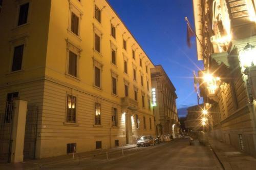 a city street at night with a large building at Hotel Beatrice in Florence