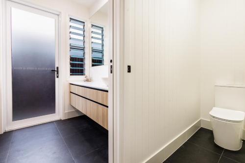 a bathroom with a toilet and a sink and a window at Sandy Soles in Agnes Water