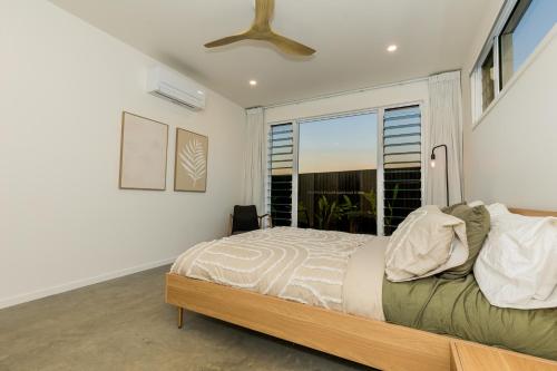 a bedroom with a bed and a large window at Sandy Soles in Agnes Water