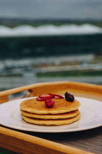 una pila de panqueques en un plato sobre una bandeja en Holiday Inn & Suites - Mexico Felipe Angeles Airport by IHG, en Zumpango de Ocampo
