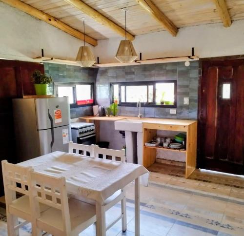 ビージャ・イチョ・クルスにあるCabaña Los Algarrobosのテーブルと冷蔵庫のあるキッチン