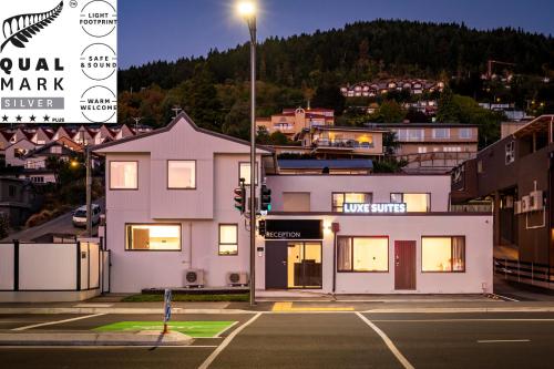 a large white building on a city street at night at Luxe Suites & Apartments in Queenstown