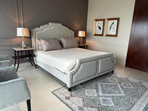 a bedroom with a bed and two tables and a couch at 1 Constitution Avenue By Goldfinch in Islamabad